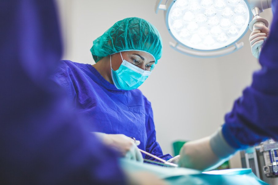woman surgeon while performing an operation on a patient