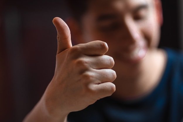 boy showing his right hand thumbs up in front of the camera